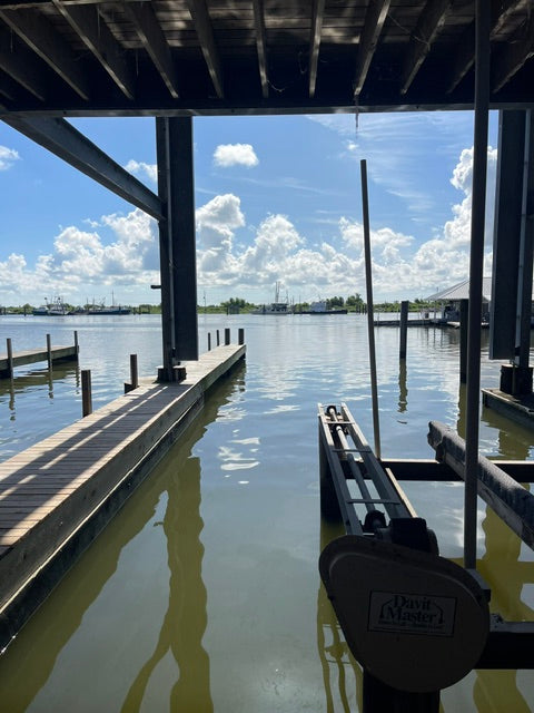 View from under a dock over calm water with a clear sky in Venice LA